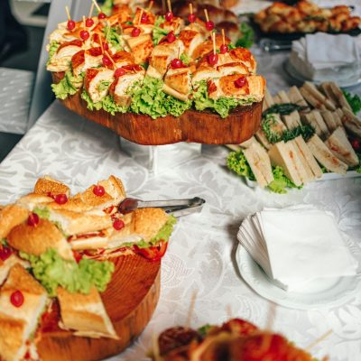 Close-up of a vibrant sandwich buffet with fresh lettuce and garnish on a tablecloth.